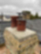 Two red chimney pots with bird guards fitted
