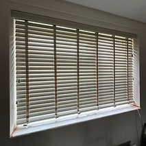 Dark wooden horizontal Venetian blinds covering a window