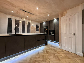 Kitchen with dark cabinets, island, and recessed lighting