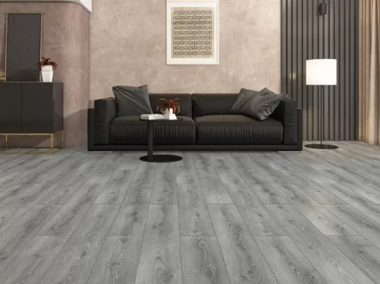 Modern living room with a sleek black sofa, grey laminate flooring