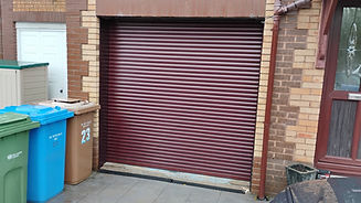 Closed maroon metal roller shutter with horizontal lines