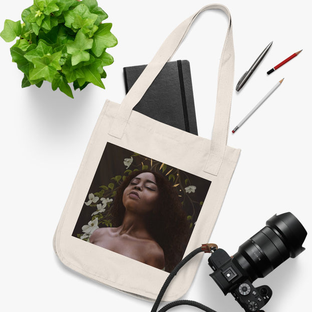 white canvas bag with a painting of a black woman in front of dogwood flowers on the front