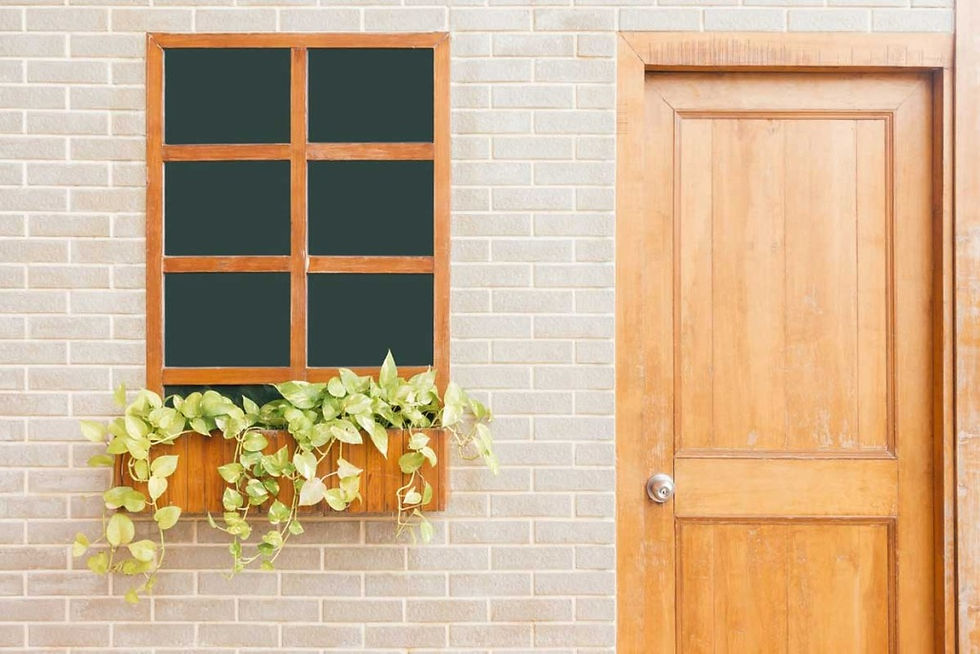 Wooden window box with plants and a door on a brick wall background
