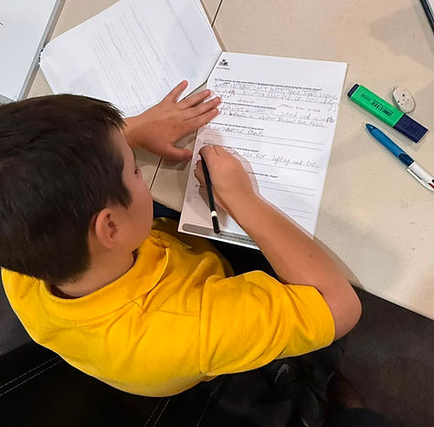 A Tutor explaining complex Maths and English concepts on a whiteboard during a comprehensive Tutoring and Exam prep class