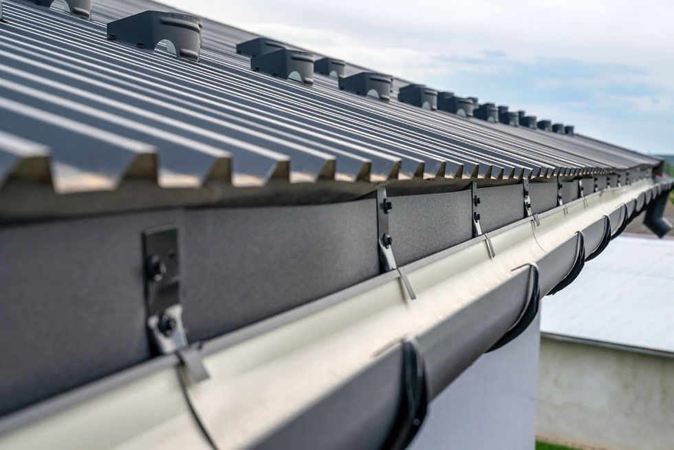 Installed gutter on metal roof. Gutter Installation for water runoff on residential building.