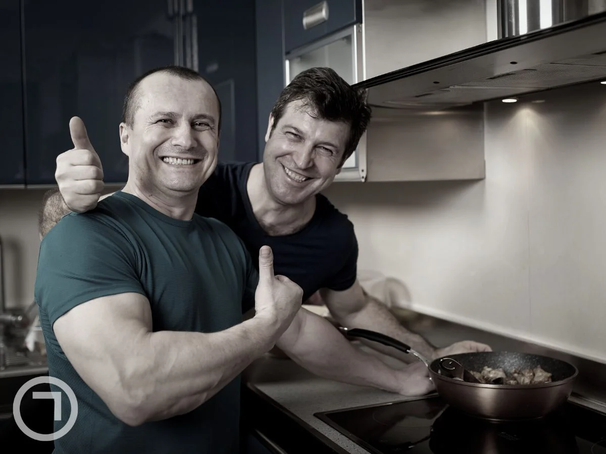 Happy men in kitchen while cooking