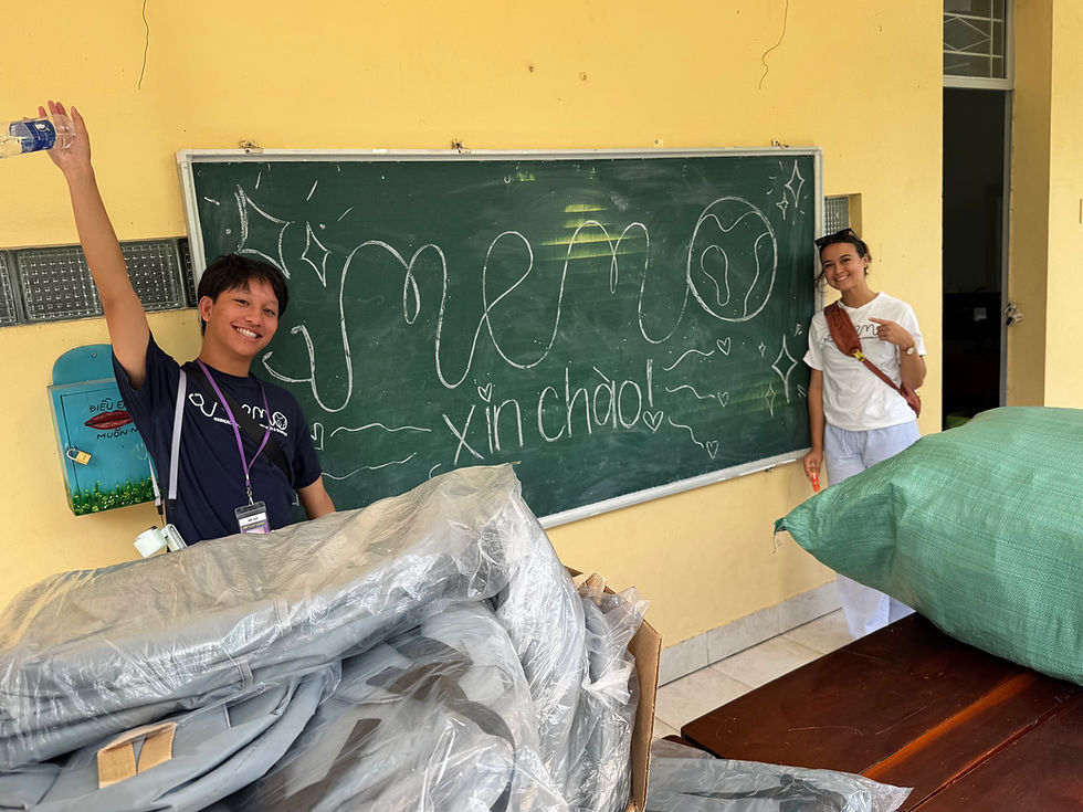 MEMObers giving a warm welcome by drawing the MEMO logo on a chalk board at Binh Hoa Nam Middle School.
