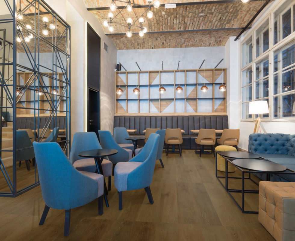 Moderne lounge met blauwe stoelen en houten vloer