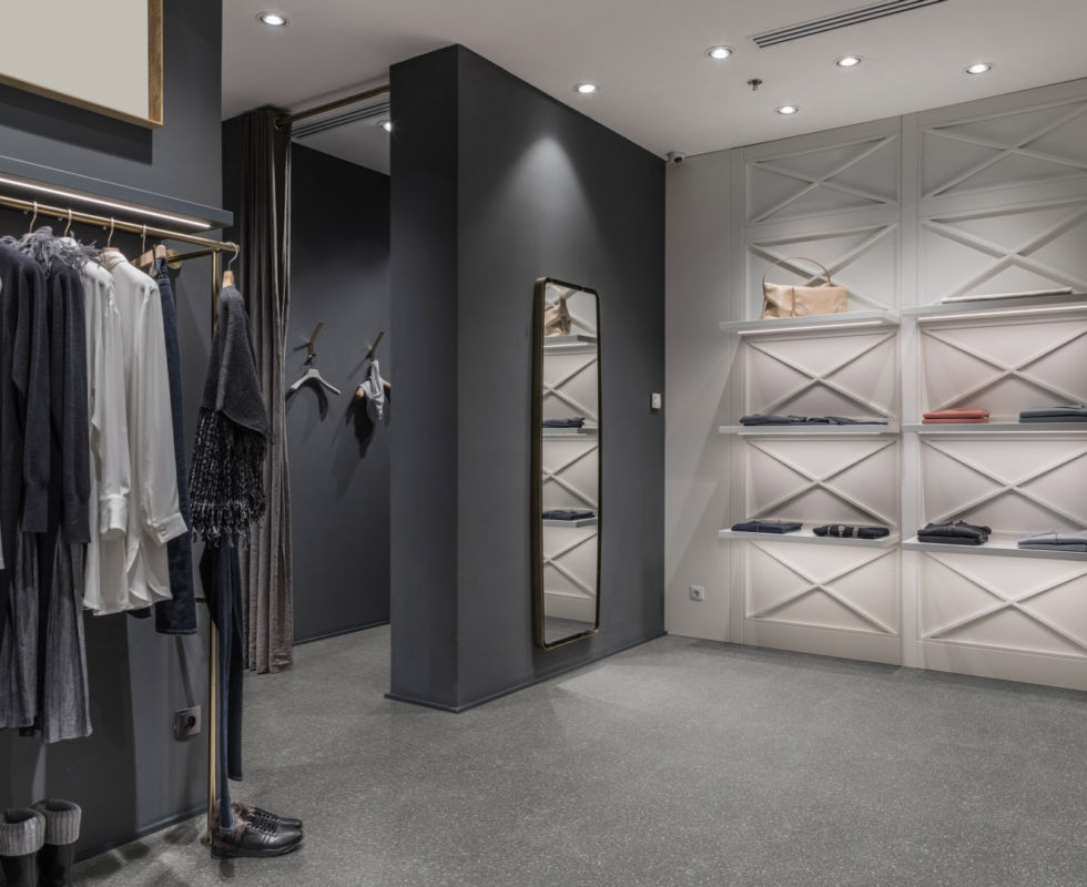 Modewinkel interieur: kledingrekken, pashokje en schappen