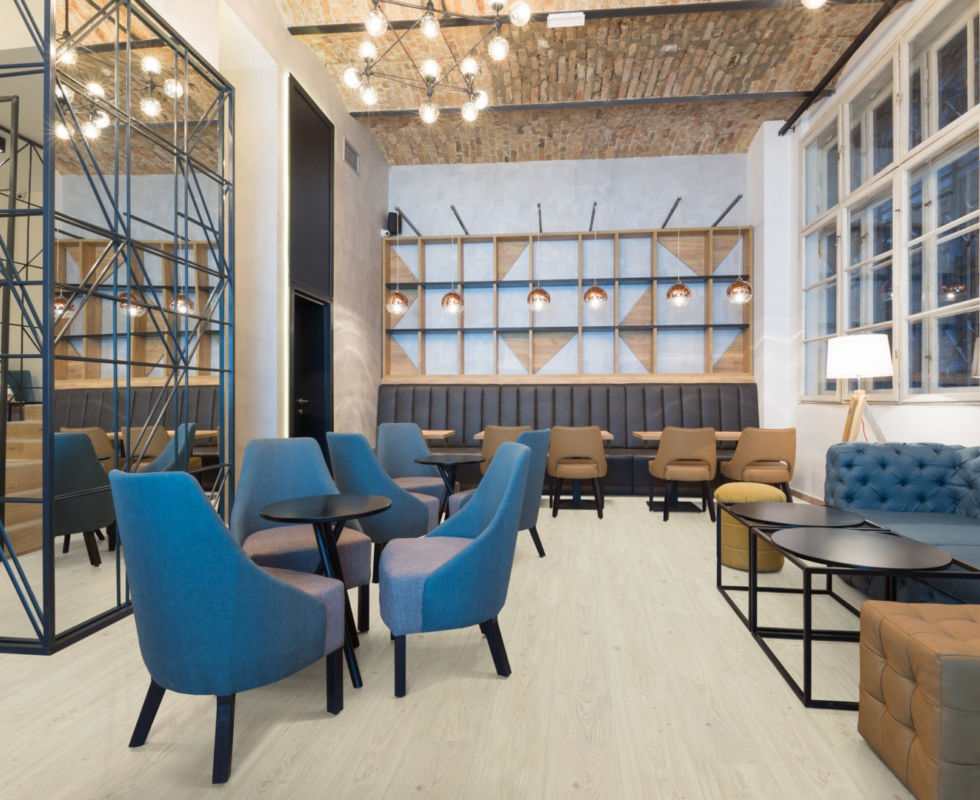 Moderne lounge met blauwe fauteuils en lichte houten vloer