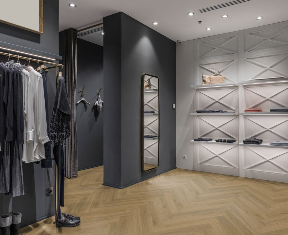 Modewinkel met visgraatvloer en kledingrekken