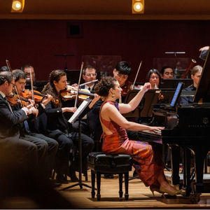A concert pianist performing with an orchestra