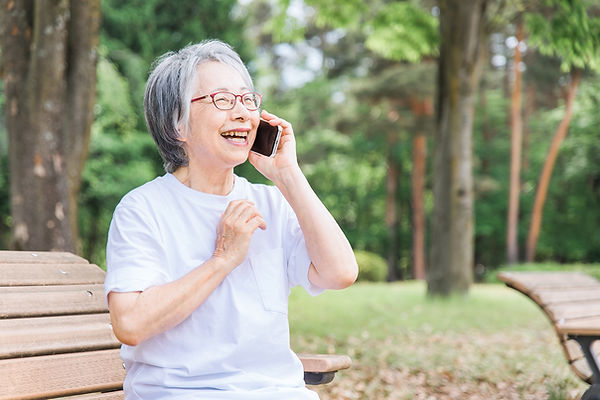 電話で話す笑顔の高齢女性.