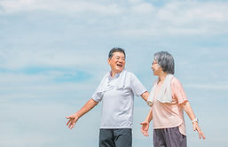 深呼吸をする笑顔のシニア夫婦.jpg
