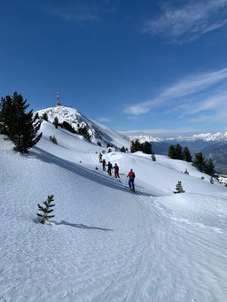 Groep toerskiërs onderweg richting de Patscherkofel met uitzicht over de bergen rond Innsbruck.
