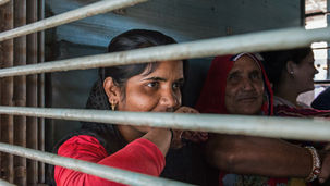 Een vrouw achter de tralies van een treinwagon op het station van Jaipur, India. Fine art fotografie door Leon Bouwman, voor serie Departure. | A woman behind the bars of a train carriage at Jaipur station. Fine art photography by Leon Bouwman for serie Departure.