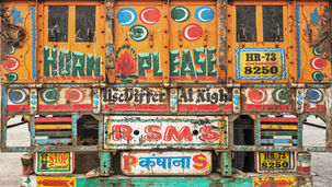 Kleurrijke handgeschilderde truck art met de tekst 'Horn Please' op de achterkant van een vrachtwagen in India. Fine art fotografie van Leon Bouwman. / Colorful hand-painted truck art featuring 'Horn Please' on the back of a truck in India. Fine art photography by Leon Bouwman.