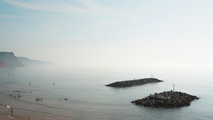 Twee rotseilanden die als golfbrekers uit de mistige zee steken bij Sidmouth aan de Jurassic Coast, Devon. Fine art fotografie van Leon Bouwman. | Two rocky outcrops acting as breakwaters in the misty sea at Sidmouth on the Jurassic Coast, Devon. Fine art photography by Leon Bouwman.