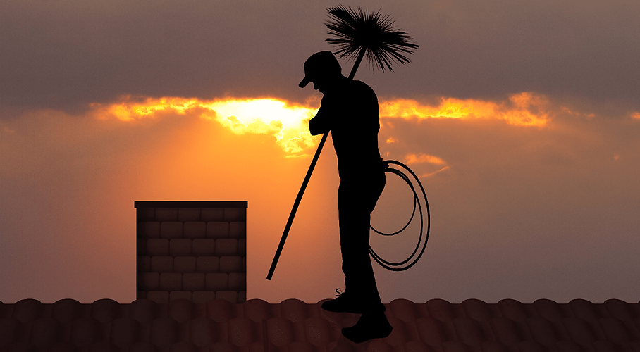 Ramoneur sur un toit, au coucher du soleil.