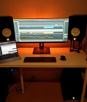 Computer and studio monitors surrounded by an orange glow