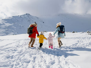 Famille marchant dans la neige dans une station de ski famille des Alpes, vacances en montagne avec enfants.