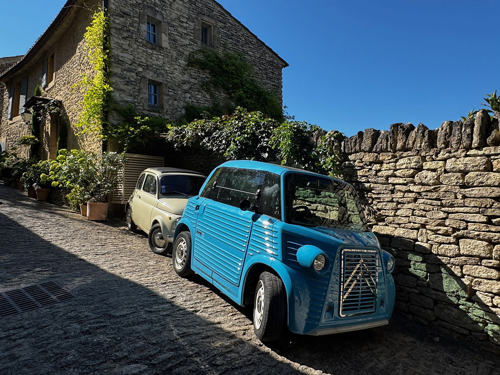 voitures anciennes dans une rue pavée d’un village du Luberon en Provence