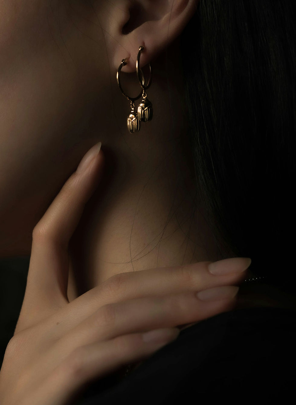 Close-up of gold hoop earrings with delicate pendants.