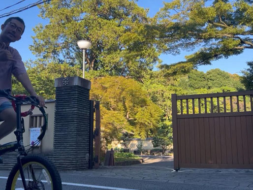 A guide riding bike in front of Japanese garden