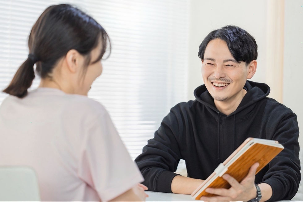 パーソナルジムで女性と楽しそうにカウンセリングをしている島村トレーナーの写真