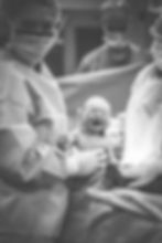 A Michigan doctor holding a baby for a Michiana birth photographer to take a picture of.