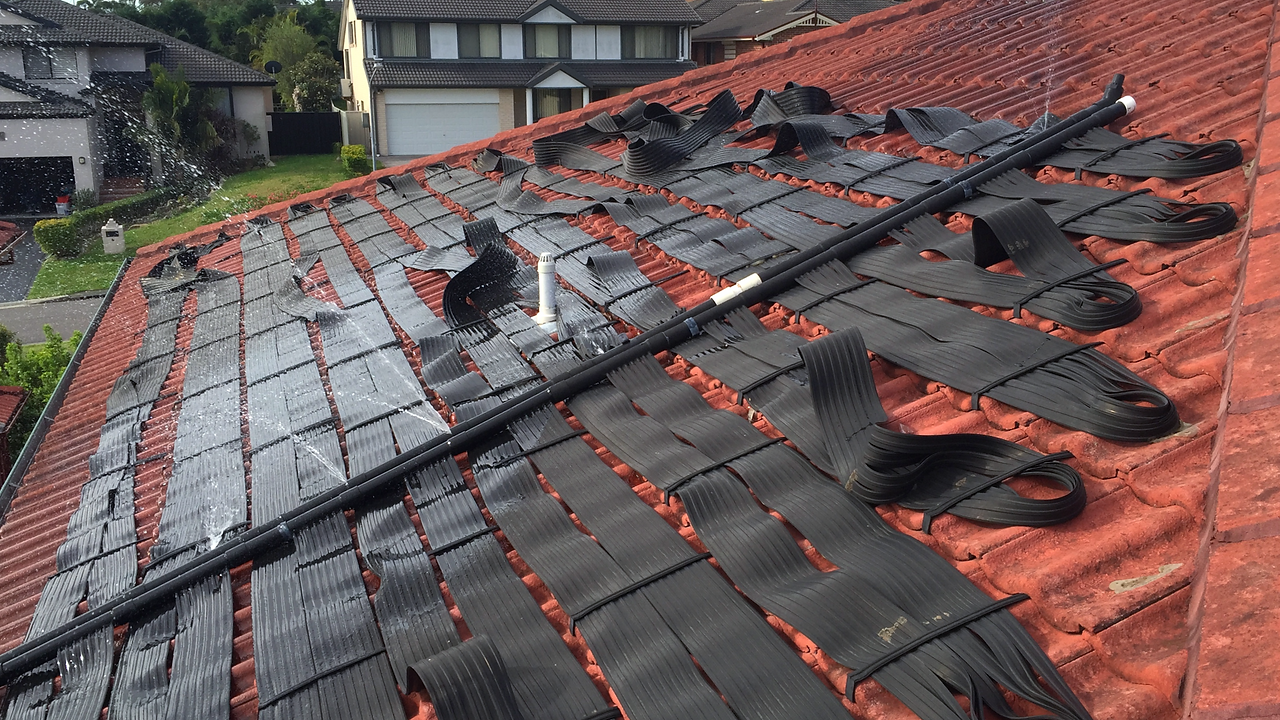Damaged strip solar pool heating panels with a water burst