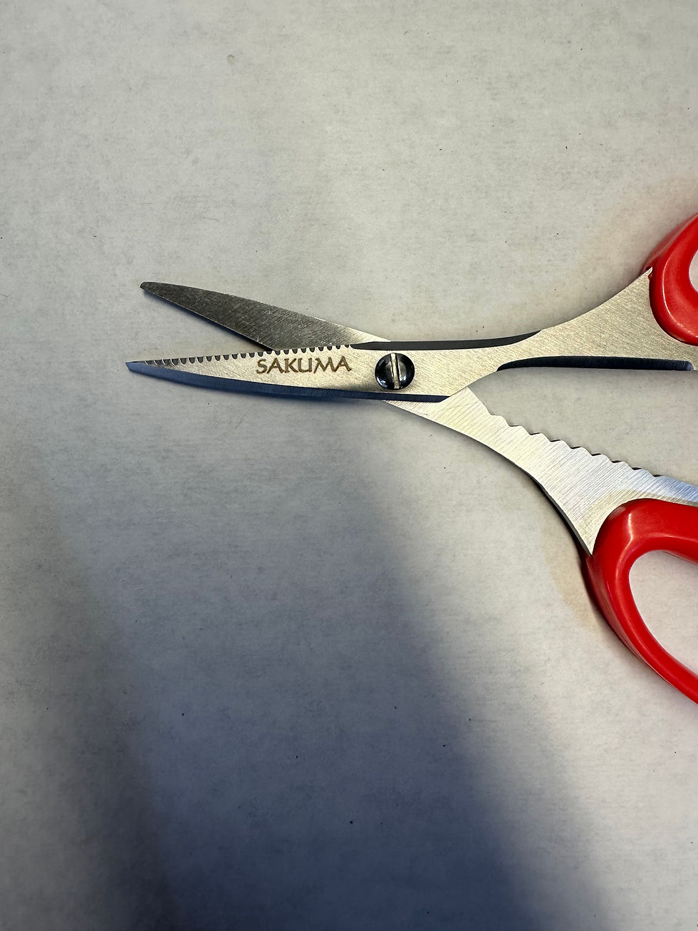 Thumbnail: Red-handled SAKUMA scissors with serrated blade