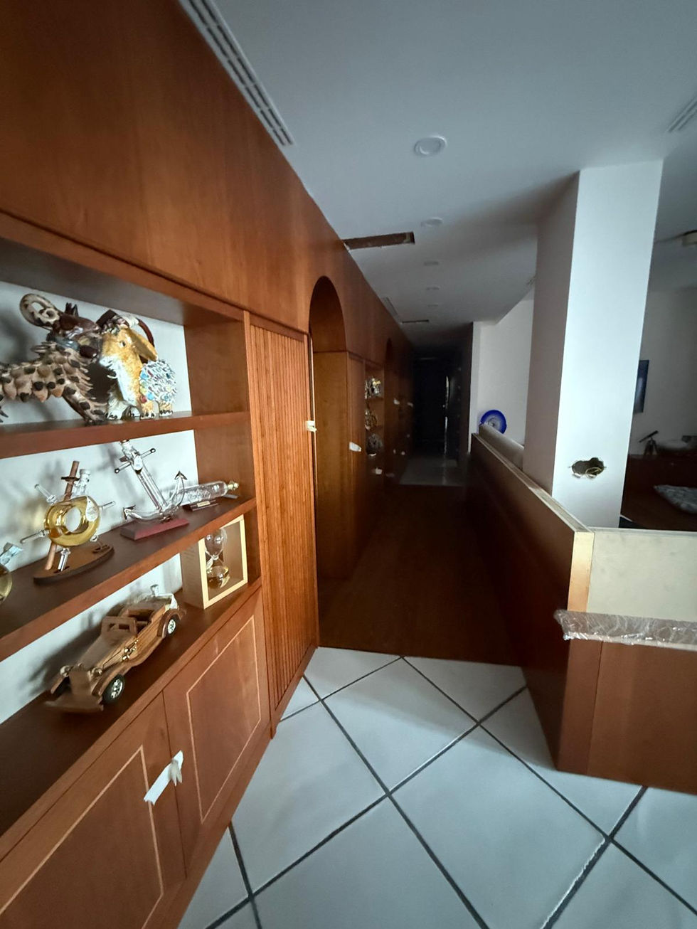 Long hallway with wooden display shelves