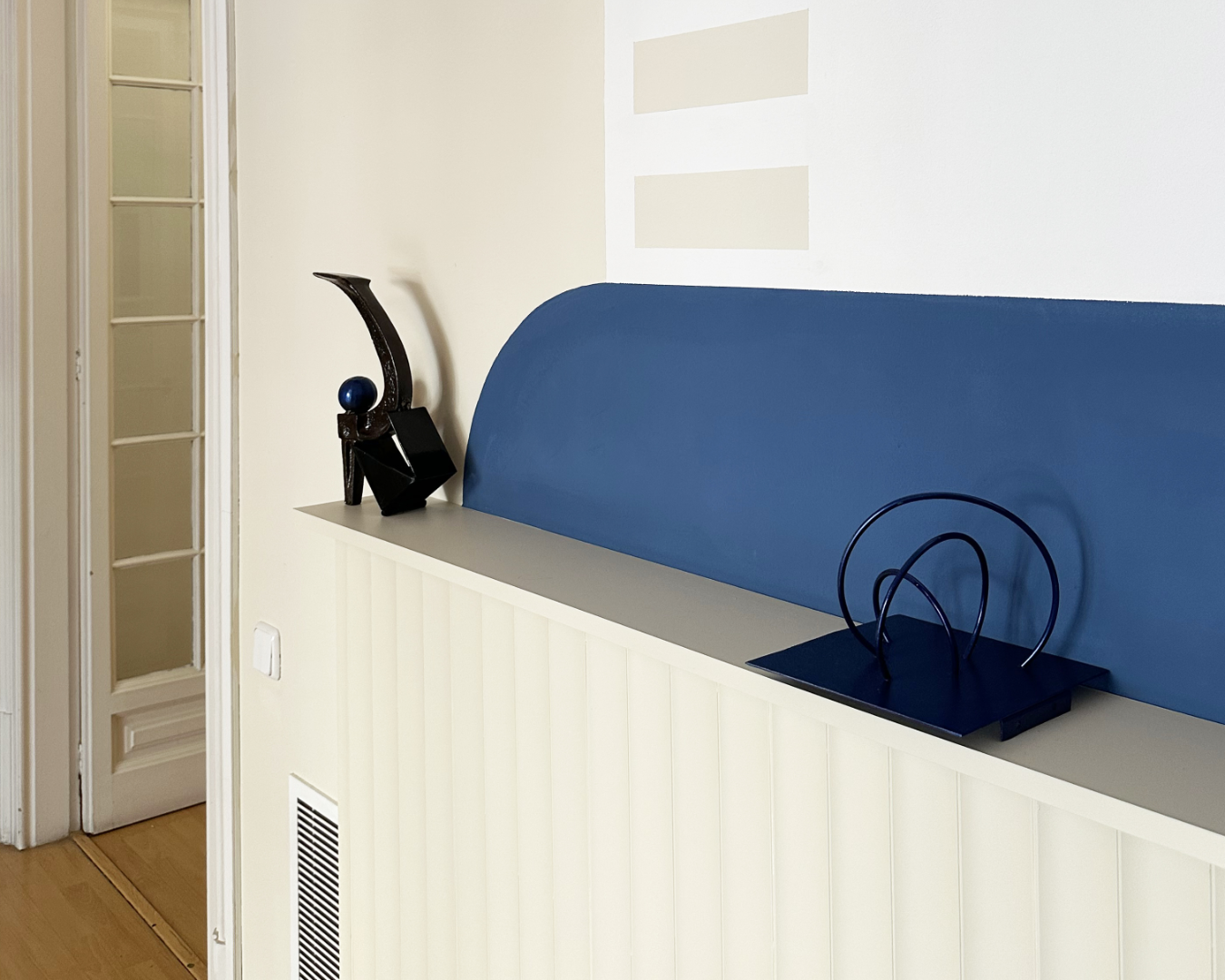 Modern hallway with shelf, blue accent, and art, PHASEZERO DESIGN design studio services.