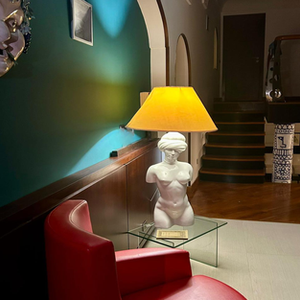 Red armchair, classical torso lamp, and staircase