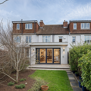 White house rear with open bi-fold doors and garden