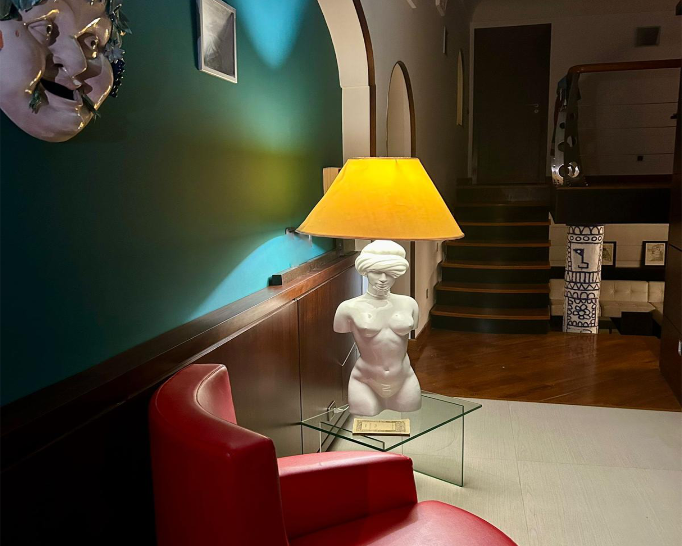 White statue lamp on table with red chair, PHASEZERO DESIGN design studio services