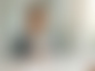 Mujer sonriente en baño, frente al espejo, sostiene un espejo de mano; hay cepillo, pasta y enjuague bucal.