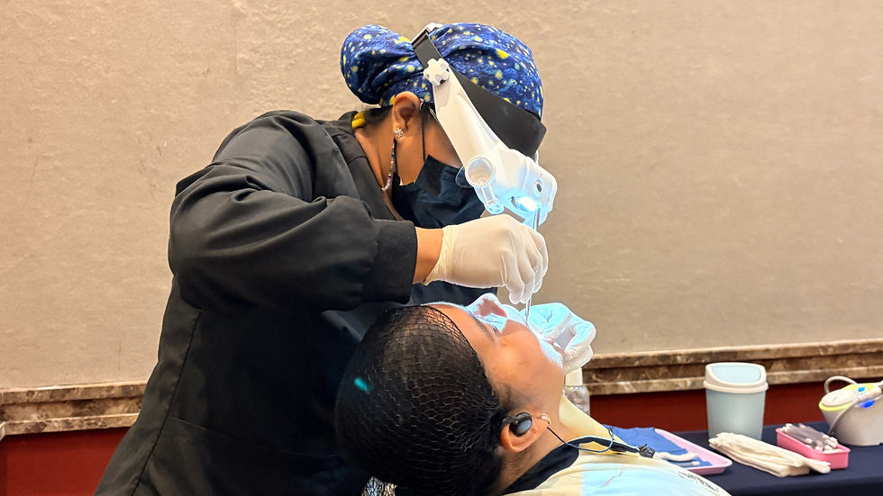 Profesional de la salud realiza revisión bucal preventiva a colaborador durante brigada de salud bucal de Grupo ROCA en El Cid Resorts.