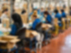 Image of a manufacturing plant with workers putting products in boxes.
