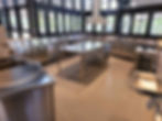 Commercial kitchen with stainless steel counters, sinks, and central island. Stainless steel maintenance and rust free