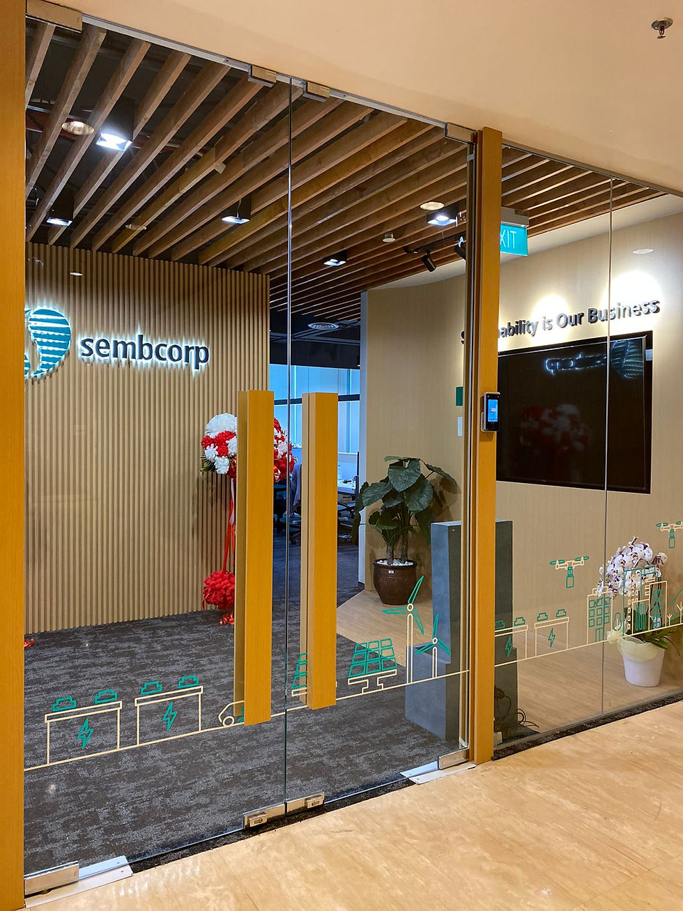 Office entrance with glass doors, wooden ceiling, and branding.
