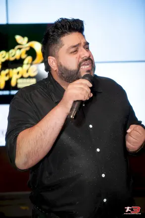 Cantante local con micrófono durante el concurso Camino al Éxito 2026 en Green Apple Restaurant