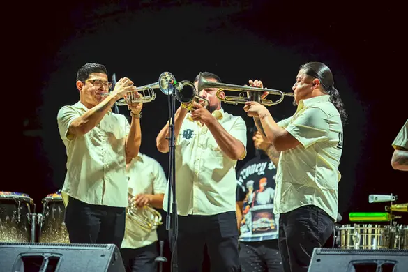 Músicos de La Renovada Banda Estrategia tocando trompetas durante su presentación