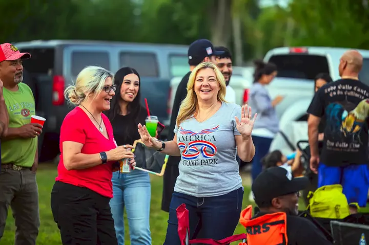 Grupo de asistentes sonriendo y disfrutando de Music in the Park en Stone Park