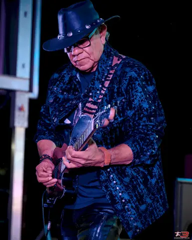 Músico con sombrero negro durante una presentación nocturna en HispanoFest 2026