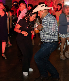 Fotografía profesional de eventos familiares latinos en Chicago mostrando invitados celebrando y bailando durante una fiesta familiar.