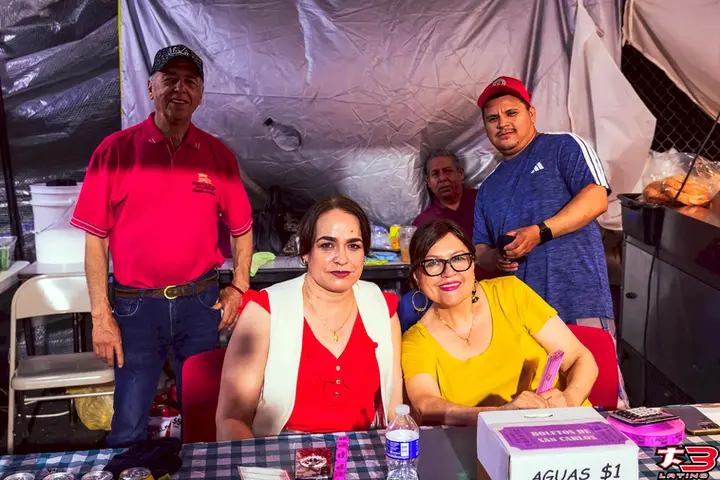 Voluntarios atendiendo un puesto de aguas frescas durante la Fiesta Patronal San Carlos Borromeo