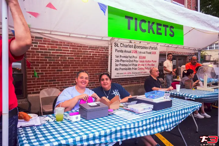 Voluntarias atendiendo el puesto de boletos de la Fiesta Patronal San Carlos Borromeo en Melrose Park