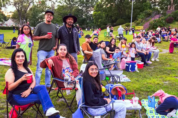 Familias y amigos disfrutando del concierto comunitario al aire libre en Stone Park